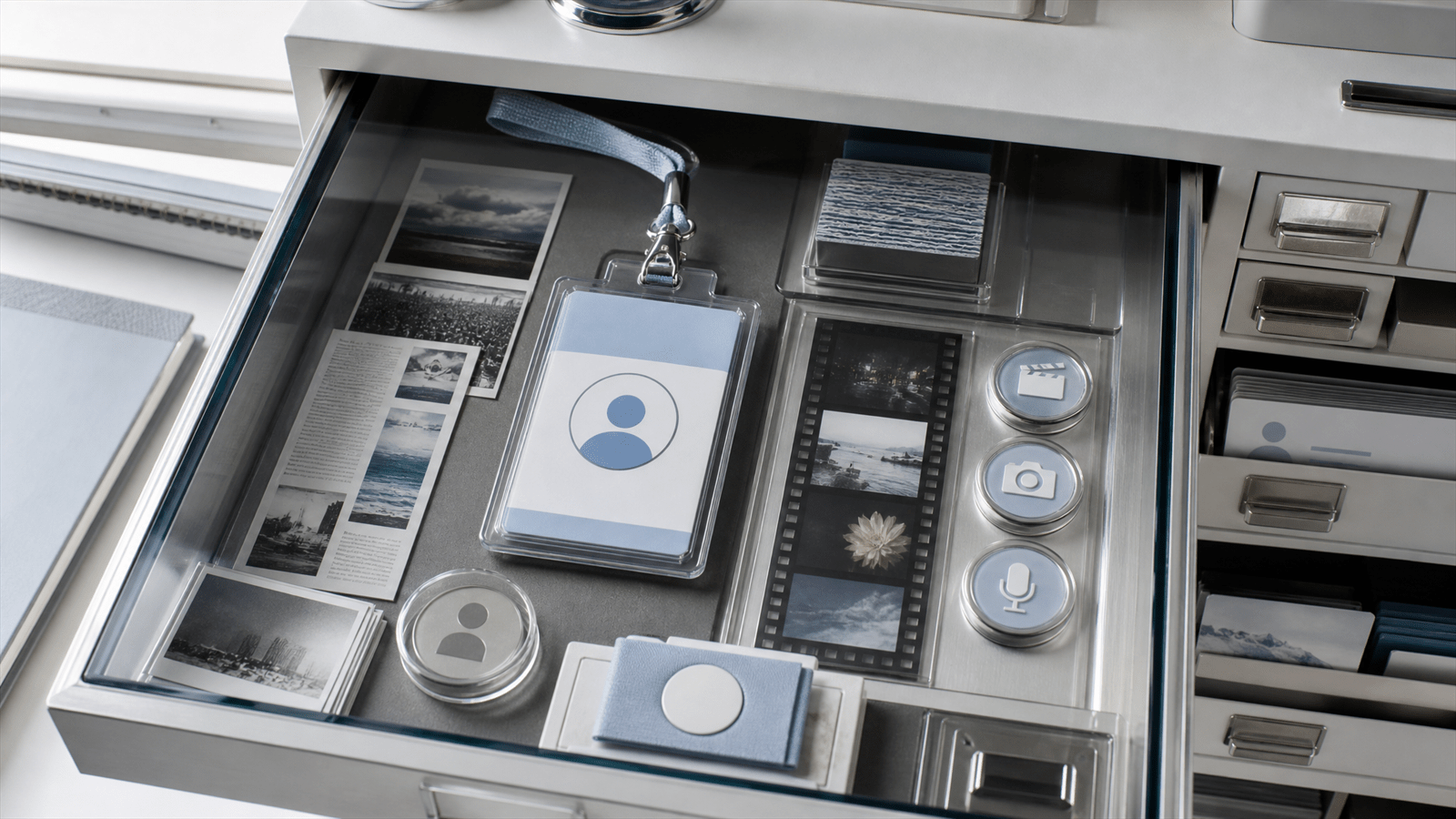 A glass publisher-identity archive with a polished profile badge, article strips, video transparencies and nested sub-brand drawers.